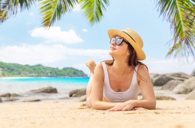 Woman lying on the sea beach enjoying and relaxing in summer