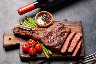 Orta pişmiş Tomahawk bifteği, kuşkonmaz ve kırmızı şarap.