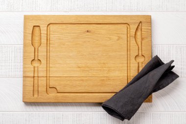 Wooden cutting board and kitchen towel. Flat lay with copy space