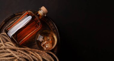 Bir şişe rom, konyak ya da viski. Eski ahşap fıçının üzerinde. Üst görünüm düzlüğü kopyalama alanı ile yatıyordu