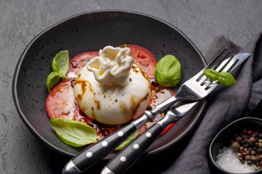 Antipasto with burrata cheese, tomatoes and basil. Italian cuisine