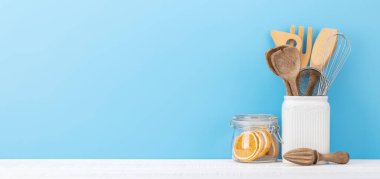 Kitchen utensils on wooden table. Front view with copy space