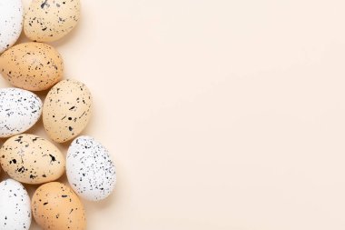 Easter eggs on a beige background with space for your greetings. Flat lay