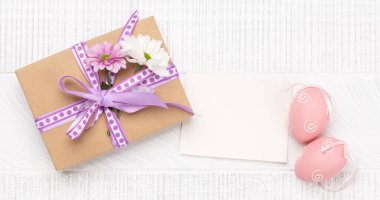 Hediye kutusu, Paskalya yumurtaları ve çiçekler ahşap arka planda selamlarınız için yer var. Düz yatıyordu