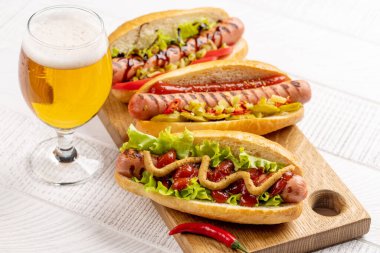 Various hot dog and beer. Homemade hotdogs on cutting board