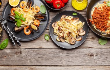 Çeşitli İtalyan makarnaları. Deniz ürünleri, mantar ve domates soslu makarna, spagetti bolonez. Üst görünüm düzlüğü kopyalama alanı ile yatıyordu