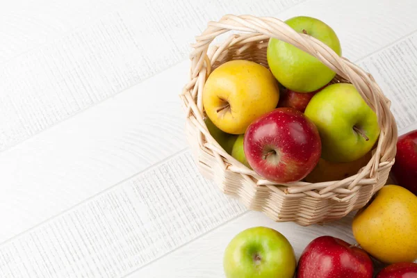 木製のテーブルの上にバスケットにカラフルな熟したリンゴの果物 コピースペース付きのトップビューフラットレイ — ストック写真