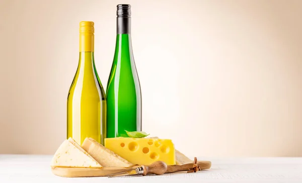 ボード上の様々なチーズと白ワイン コピースペースとベージュの背景の上に — ストック写真