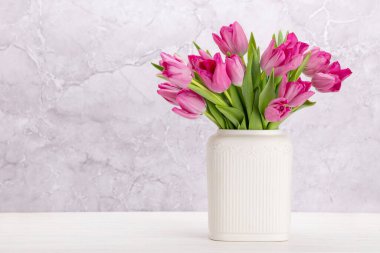 Fresh pink tulip flowers bouquet. On white wooden table with copy space
