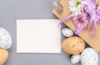 Hediye kutusu, Paskalya yumurtası ve tebrik kartı ile birlikte çiçekler. Düz yatıyordu