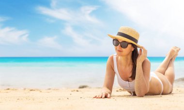 Woman lying on the sea beach enjoying and relaxing in summer