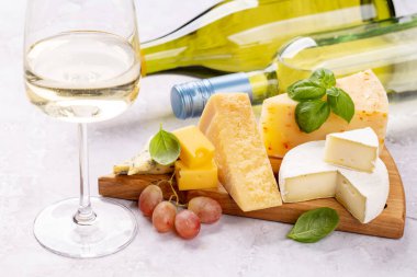 Various cheese on board and white wine