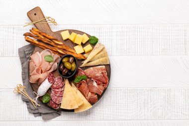 Antipasto tahtası ve çeşitli et ve peynir atıştırmalıkları. Kopyalama alanı olan düz