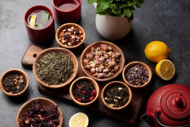 Çeşitli kurutulmuş çay ve çaydanlık. Bitki, yeşil, böğürtlen ve siyah çay yaprakları. Üst görünüm