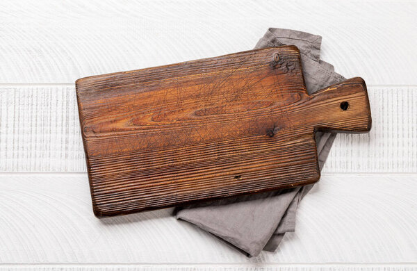 Wooden cutting board and kitchen towel. Flat lay with copy space