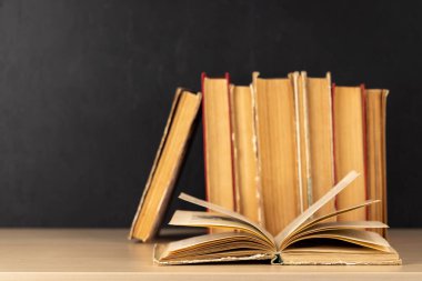 Old books on a table, with one book open and copy space for your text clipart