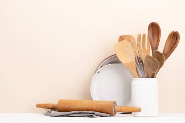 Kitchen utensils on wooden table. Front view with copy space