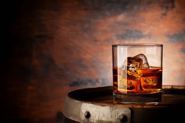 古い樽に氷のキューブとウイスキーのガラス 木製の背景にコピースペースを持つ — ストック写真