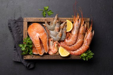 Karides, Langoustine ve alabalık bifteği gibi taze deniz ürünleri manzarası. Düz yatıyordu