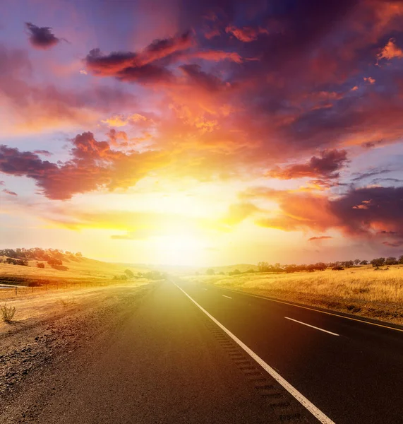 劇的な空と日没の田園風景の中に空のアスファルトの道路 — ストック写真