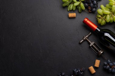 Masada şarap şişesi, üzüm, tirbuşon ve şarap mantarları var. Mesaj için bolca yer var. Düz yatıyordu