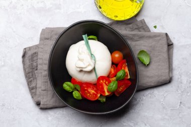 Burrata peyniri, çeşitli domatesler ve zeytinler. İtalyan mutfağı. Düz yatıyordu