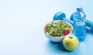 Sağlıklı yaşam tarzı, spor ve diyet konsepti. Dambıl ve sağlıklı yiyecekler. Metnin için boşluk ile