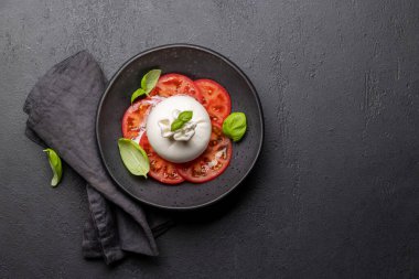 Antipasto with burrata cheese, tomatoes and basil. Italian cuisine. Flat lay with copy space