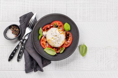 Antipasto with burrata cheese, tomatoes and basil. Italian cuisine. Flat lay with copy space