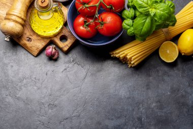 Yemek yapmak için gerekli malzemeler. İtalyan mutfağı. Makarna, domates, fesleğen. Kopyalama alanı olan düz