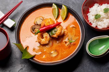 Tayland Tom Yum Çorbası, deniz mahsulü ve bir kase pirinç.
