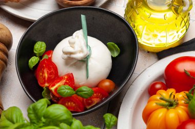 Burrata peyniri, çeşitli domatesler ve zeytinler. İtalyan mutfağı
