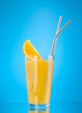 Mavi arkaplanda kopyalama alanı olan portakal suyu