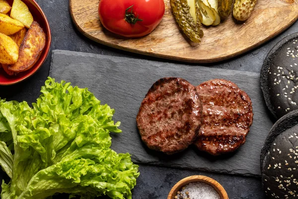 Ev yapımı sığır eti köftesi ve malzemeler. Düz yatıyordu