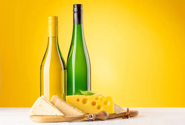 ボード上の様々なチーズと白ワイン 黄色の背景にコピースペース — ストック写真