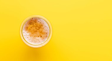 Parlak sarı arka planda fotokopi alanı olan soğuk bir bira. Düz yatıyordu