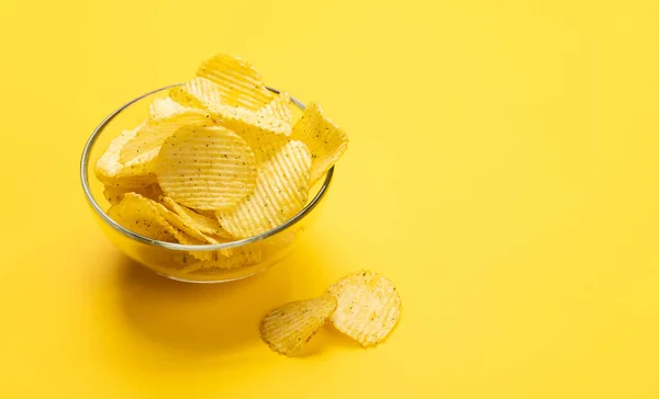 Bowl of chips on a yellow background with copy space