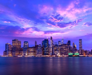 New York 'ta nehrin karşısındaki Manhattan silueti günbatımında etkileyici mimari ve modern şehir manzarasını gözler önüne seriyor.