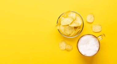 Fotokopi alanı olan canlı sarı bir arka planda bira ve patates kızartması. Düz yatıyordu