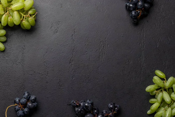 stock image A top view of various grapes on a stone table, with plenty of open space for text. Flat lay