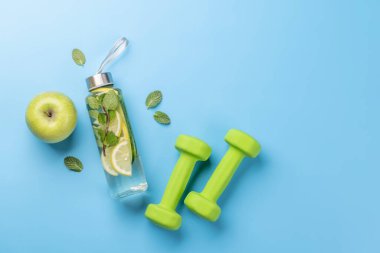 Sağlıklı yaşam tarzı, spor ve diyet konsepti. Dambıl ve sağlıklı yiyecekler. Mesajın için de yer var. Düz yatıyordu