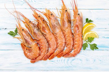 Langoustines gibi taze deniz ürünleri. Tahta masanın üzerinde yatıyordu.