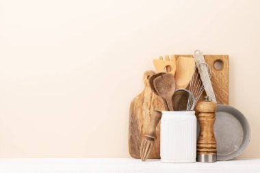 Kitchen utensils on wooden table. Front view with copy space