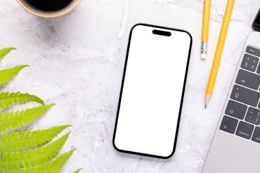 Yeşil doğa yapraklarıyla çevrili bir masada boş ekranı olan akıllı telefon, mükemmel tasarım modeli.