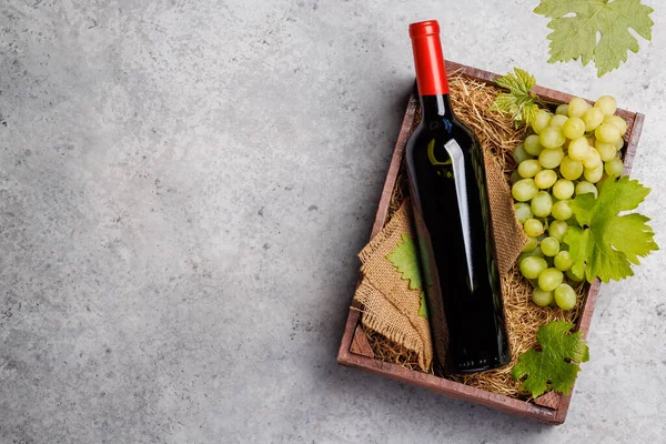 素朴な木製の箱に提示赤ワインボトルと新鮮なブドウ コピースペース付きフラットレイアウト — ストック写真