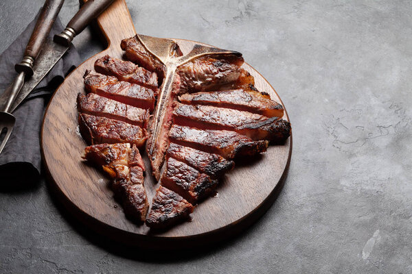 Grilled porterhouse beef steak. Sliced T-bone with herbs and spices. With copy space