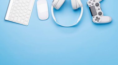 Oyun ekipmanları ve teknolojik aksesuarlar mavi arka planda, oyun ve teknik temalar için mükemmel. Kopyalama alanı olan düz