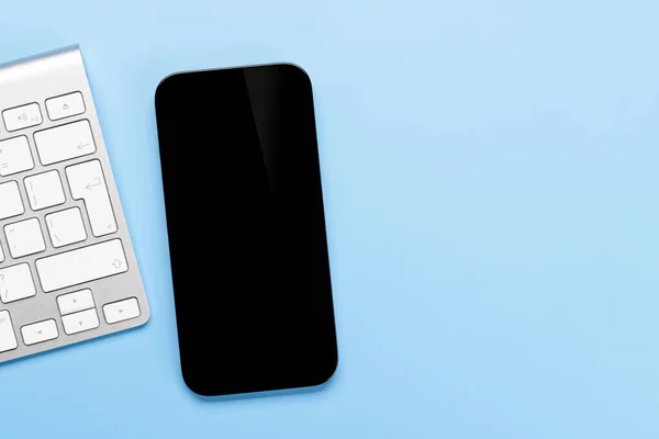 あなたのデザインのモックアップに最適で 机の上に空白の黒い画面のスマートフォン — ストック写真