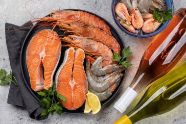 Beyaz ve gül şarabı eşliğinde karides, langoustines ve alabalık bifteği gibi taze deniz ürünlerinin üst görüntüsü
