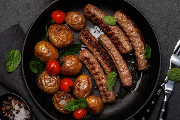Delicious Grilled Sausages Potatoes Sizzling Frying Pan Flat Lay — Stock Photo, Image